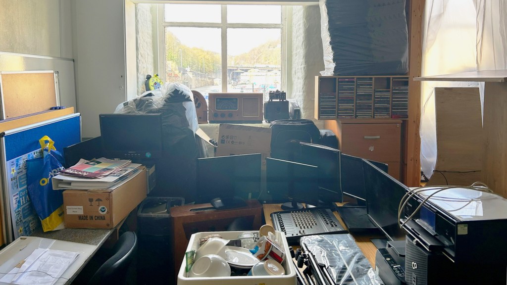 A view into the main studio of Phenix's new home. There are monitors, cables and boxes everywhere. 